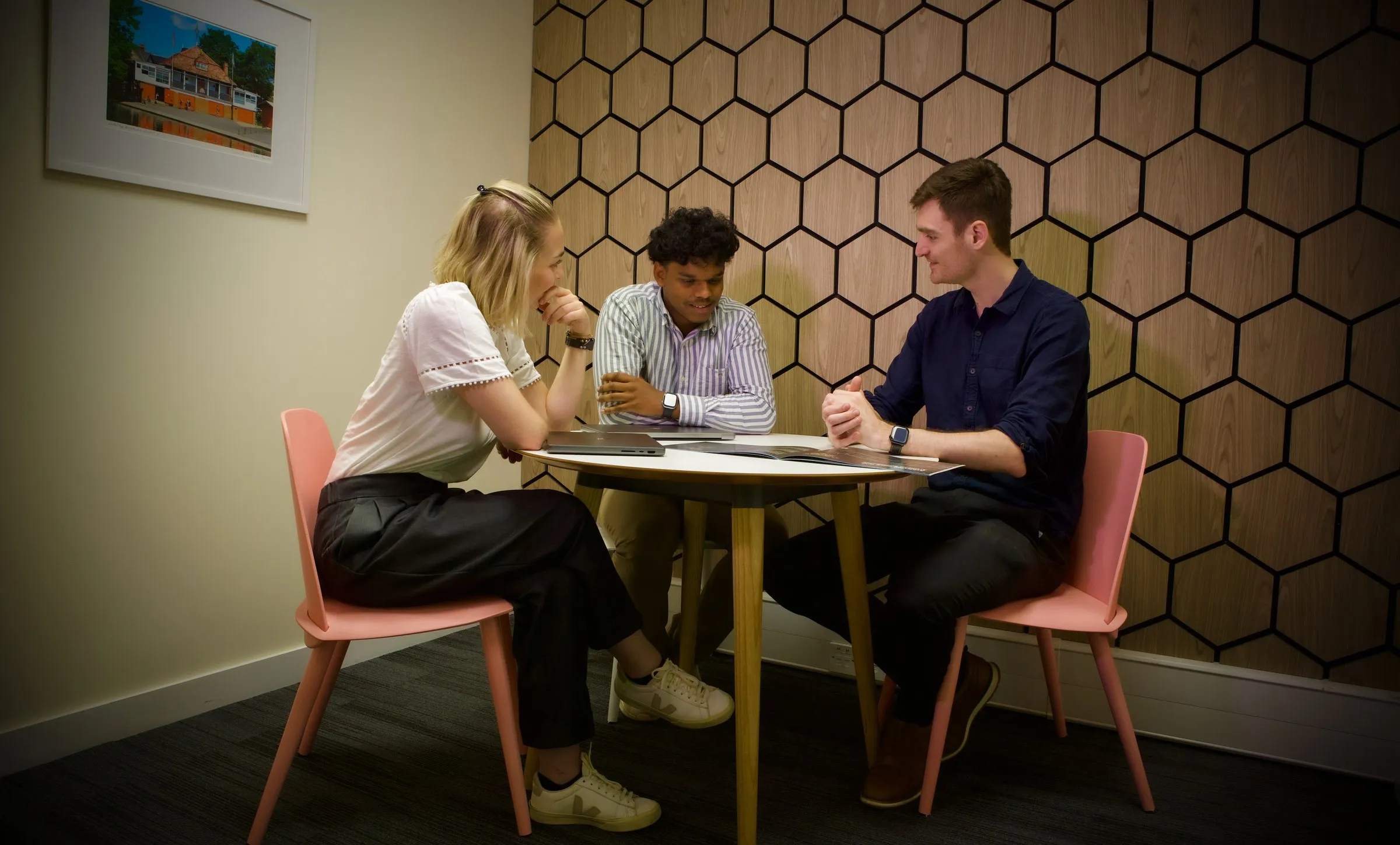 Three members around a table in a Studio meeting room