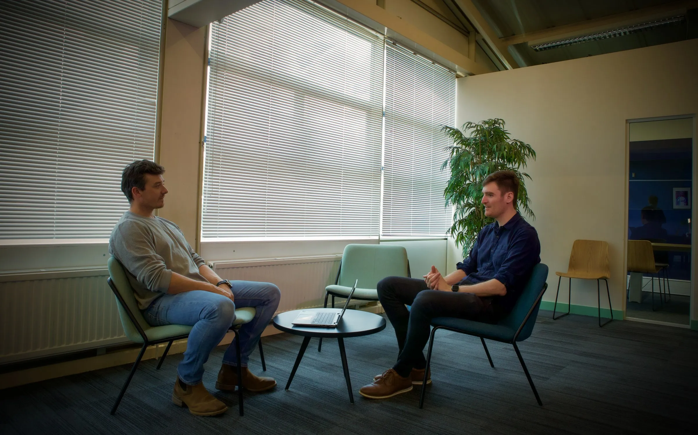Two members talking in the lounge seating by the windows